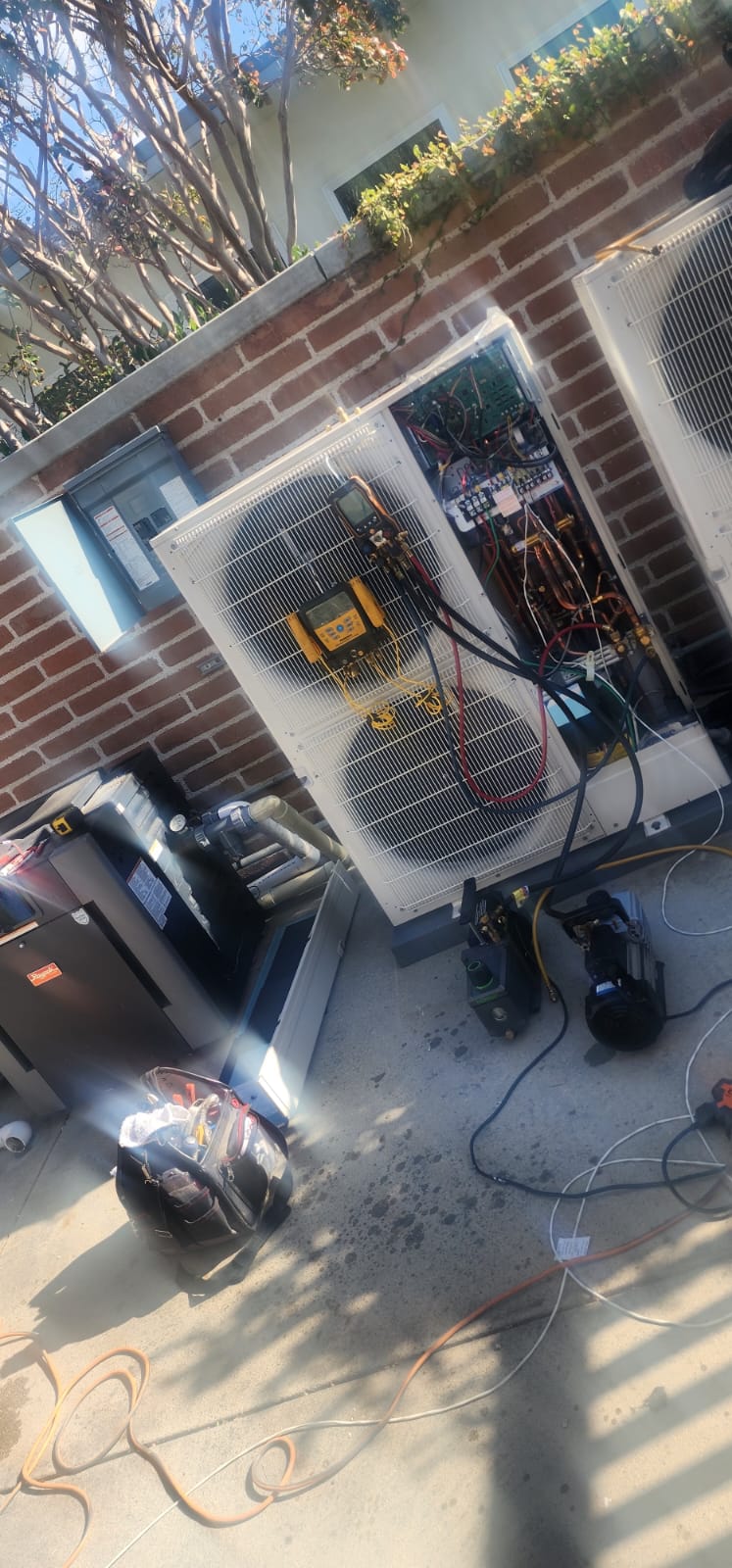 Outdoor HVAC system connected to diagnostic and evacuation equipment during service