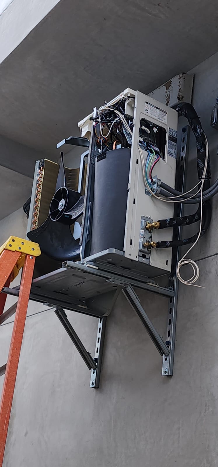 Wall-mounted HVAC unit opened for component inspection and repair