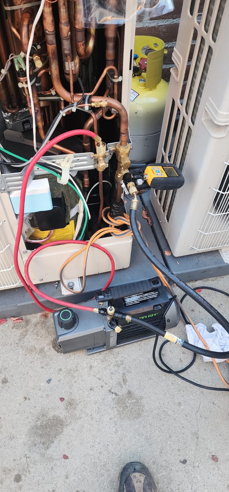 Refrigerant service equipment connected during an outdoor HVAC repair