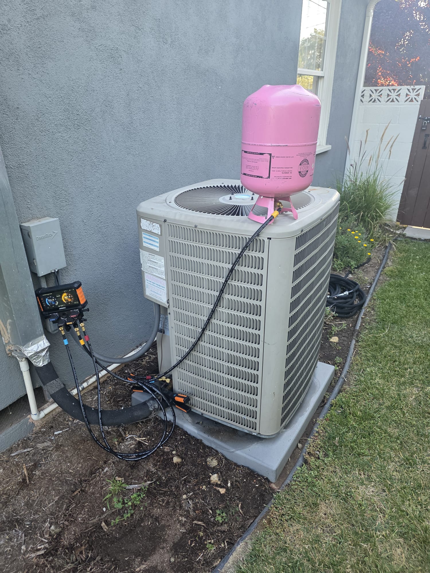 Outdoor residential air conditioning condenser being serviced